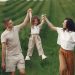 Joyful family moment in a green field during summer, capturing love and playfulness.